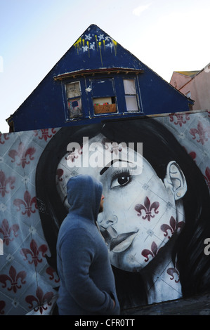 Stati Uniti d'America Sud della California a Los Angeles Venice Beach L.A. CA uomo camminare davanti a un murale di una donna di fronte a un intavolato house Foto Stock