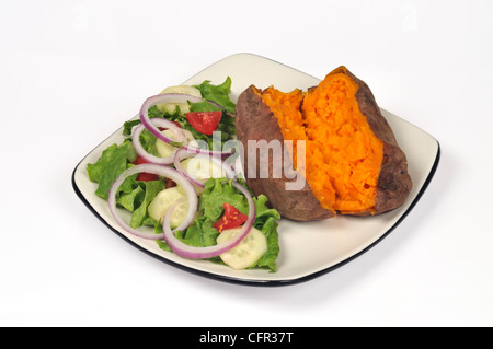 Cuocere al forno yam patata dolce tagliato a metà con burro fuso e insalata di giardino sulla piastra bianca su sfondo bianco tagliato fuori Foto Stock