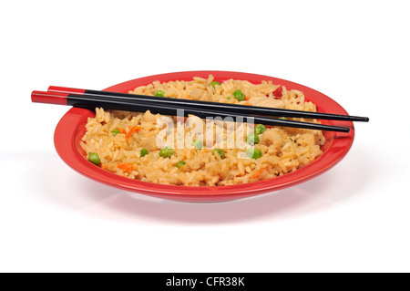 Oriental chicken fried rice con verdure e bastoncini isolata sulla targhetta rossa Foto Stock