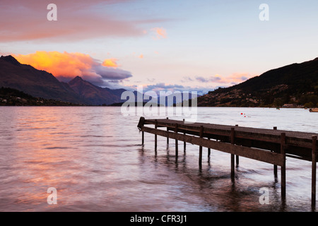 Un vecchio molo sulle rive del lago Wakatipu, Queenstown, Otago, Nuova Zelanda, e Queenstown in distanza. Foto Stock