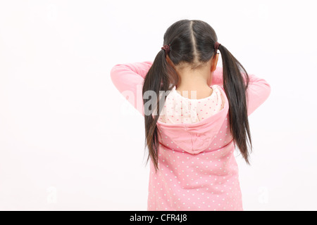 Il pianto in piedi bambina, vista posteriore Foto Stock