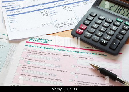 Foto di un Regno Unito autovalutazione ritorno fiscale con la calcolatrice e fogli paga. Foto Stock