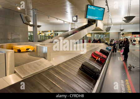 In attesa di valigie al carosello bagagli nella sala degli arrivi presso l'Aeroporto di Oslo Norvegia Europa Foto Stock