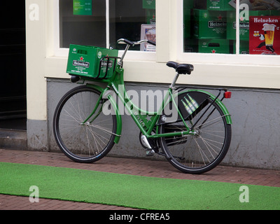 Verde Heineken in bicicletta in parte anteriore del marchio Heineken flagship store in Amsterdam Paesi Bassi Foto Stock