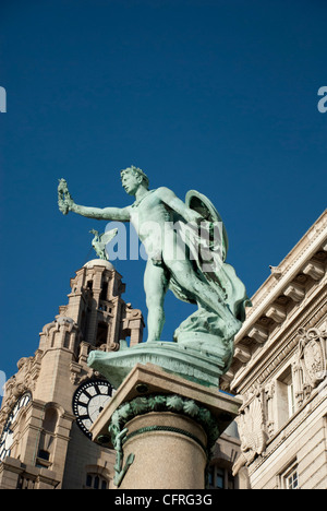 Liverbirds sulla sommità del Royal Liver Building sul lungomare a Liverpool con una statua in primo piano Foto Stock