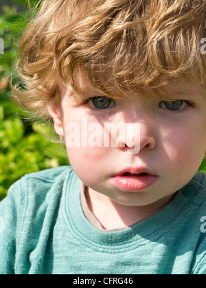 Outdoor Ritratto di 18 mese ragazzo con Tousled capelli biondi Foto Stock