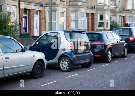 Smart auto parcheggiate in parallelo lateralmente in uno stretto spazio di parcheggio Foto Stock