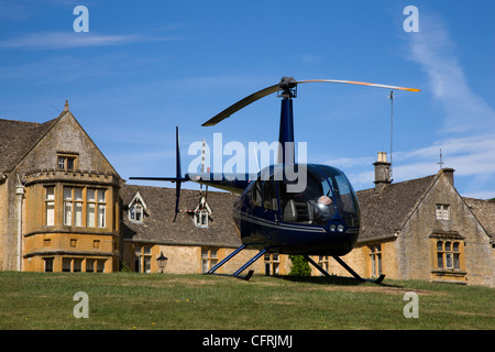 Il Lords of The Manor Hotel con elicottero parcheggiato sul prato in Upper Slaughter, Gloucestershire Foto Stock