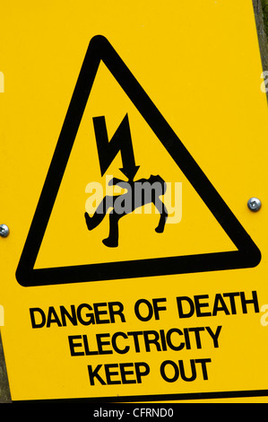 Pericolo di morte e di folgorazione. Elettricità triangolare cartello segnaletico. Regno Unito Foto Stock