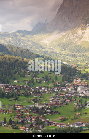 Città alpina famosa Grindelwald in valle al tramonto nella parte anteriore del Monte Eiger north face, Svizzera Foto Stock