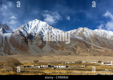 Maan borgo sotto il nitido cielo azzurro e le cime innevate della gamma Pangong in background. Foto Stock