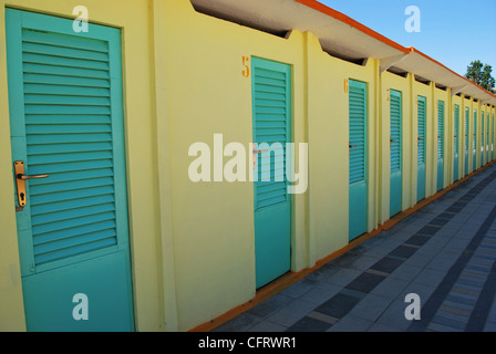 Riga in prospettiva del turchese e giallo capanne sulla spiaggia, Rimini, Italia Foto Stock