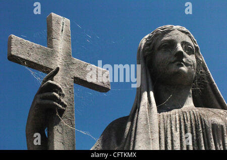 Jan 16, 2007 - Buenos Aires, Argentina - ragnatele coprire la croce di un sorridente statua in cima di un oggetto contrassegnato per la rimozione definitiva elaborata in Buenos Aires' il cimitero di Recoleta, un cimitero per i ricchi e i potenti di Argentina si trova in un quartiere esclusivo. Il cimitero ha le grazie per il Paese più influente e Foto Stock