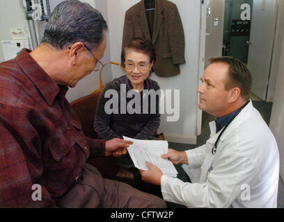 Il dott. Michael O'Brien discute i risultati delle analisi di laboratorio con Dong Hoon Cho e sua moglie Oak Kyung Cho, di Castro Valley presso la sua pratica medica Martedì, 23 gennaio 2007, in Castro Valley, California. Recentemente O'Brien ha cambiato la sua pratica alla carica considerevole del canone annuo e limitando la dimensione della sua pratica, a s Foto Stock