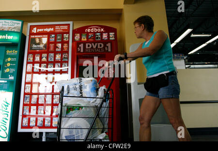 (Tampa 2/26/08)--1) Shoppers presso il Wal-Mart Neigbhrhood Mercato, passare un nuovo riquadro rosso la macchina su Martedì mattina. Casella rossa è un chiosco distributore automatico che si trova mediante la porta a molti esercenti che eroga circa 100 diversi DVD di $ 1 al giorno. Ci sono già più di queste macchine distribuite là fuori Foto Stock