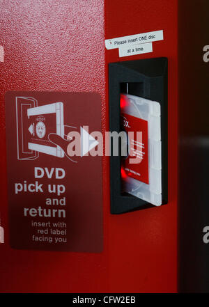 (Tampa 2/26/08)--3) un DVD viene fornito al di fuori di un riquadro rosso vending chiosco dopo Xann Leseberg (CQ), di Brandon, pagato per affittare il martedì mattina al Wal-Mart Neigbhorhood mercato. Casella rossa è un chiosco distributore automatico che si trova mediante la porta a molti esercenti che eroga circa 100 diversi DVD di $ 1 al giorno Foto Stock
