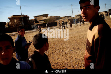 Feb 11, 2007 - Siniyah Salah ad Din, Iraq - bambini di giocare su un campo di calcio come soldati dal 303Polizia Militare Company e la polizia irachena e soldati vai su di un pattugliamento comune in Siniyah. (Credito Immagine: © Andrew Craft/l'Fayetteville Observer/ZUMA Press) Foto Stock