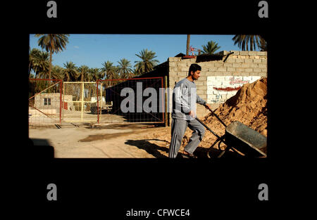 Feb 19, 2007 - Baghdad in Iraq - equitazione nel sedile posteriore di un Humvee guardare il paesaggio iracheno pass sembra simile a guardare la TV, come la forma della finestra o la sensazione che ho avuto una vera e propria connessione con ciò che stava succedendo sull'altro lato. Un iracheno uomo va circa il suo lavoro come i paracadutisti da Foto Stock