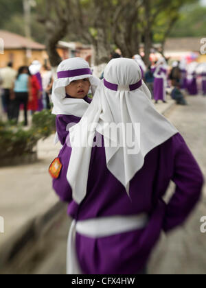 In osservanza della Quaresima in Antigua (la) di Antigua Guatemala, le celebrazioni cattoliche che conduce alla Settimana Santa, immagini di Gesù e della Vergine Santa sono portati dalle loro chiese attraverso la città sulle spalle dei devoti seguaci lungo con altri fedeli, visto qui vestito di porpora accappatoi w Foto Stock