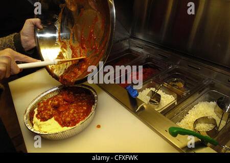 Kris Birmingham, centro aggiunge ingredienti per la carnosa Cheesy lasagne piatto durante una riunione informale a grande apertura per gli amici e la famiglia a Super cene in concordia, California Mercoledì 11 Aprile, 2007. (Nader Khouri/Contra Costa Times) Foto Stock