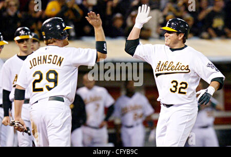 Oakland Athletics' Jack Cust, right, gets a handshake from third base coach  Tony DeFrancesco after Cust hit a two-run home run off Texas Rangers' Eric  Hurley in the first inning of a