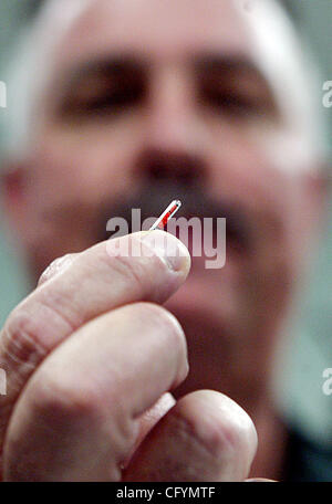 052307 w ha incontrato il personale di chip Foto di Damon Higgins/Palm Beach post 0038556A - Wellington - David Soria, MD, Capo del Dipartimento di Medicina di emergenza a Wellington Regional Medical Center, utilizza un ago per inserire un chip nel braccio di Sgt. Mike Tranchant del Palm Beach sceriffo della contea de Foto Stock