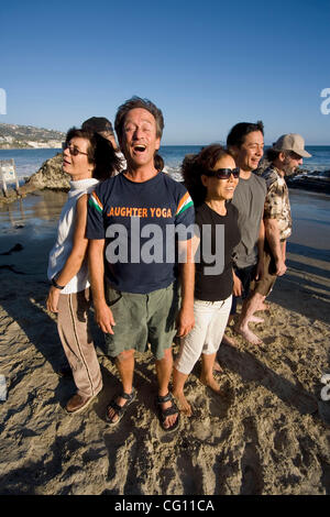 Il leader di un "Risate Yoga Club" definisce un esempio per i suoi membri come si incontrano in una località di mare in Laguna Beach, CA. Ritenendo che "la risata è la migliore medicina", essi si impegnano in risate per motivi terapeutica come divertimento. Modello di rilascio Foto Stock