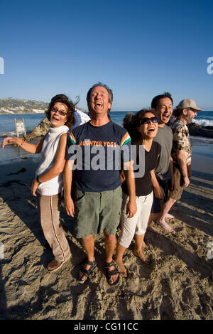 Il leader di un "Risate Yoga Club" definisce un esempio per i suoi membri come si incontrano in una località di mare in Laguna Beach, CA. Ritenendo che "la risata è la migliore medicina", essi si impegnano in risate per motivi terapeutica come divertimento. Modello di rilascio Foto Stock