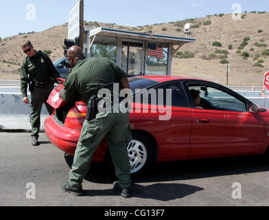 Luglio 23, 2007 Jamul, CA confine agenti PATROL SEAN RANDICH, sinistra e ANTHONY PURKETT, destra controlla il tronco di un automobile che viaggia sull'autostrada 94 vicino Dulzura, California, a Jamul Pattuglia di Confine checkpoint. Laura Embry/San Diego Union-Tribune/Zuma Press, copyright 2007 San Diego Union-Tribune Foto Stock