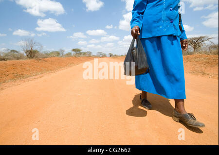 2 agosto 2011 - Kayalambi (villaggio, Kenya - Agosto 2, 2011, Kayalambi, Kenya - Contadino Joyce Wambua ritorna alla sua casa in zone aride Kathonzweni quartiere meridionale di Kenya dopo l'acquisto di verdure a un mercato locale. Nonostante la sua notevolmente migliorato la produttività dei terreni utilizzando tecniche ha appreso attraverso un Foto Stock