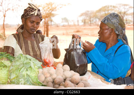 2 agosto 2011 - Kayalambi (villaggio, Kenya - Agosto 2, 2011, Kayalambi, Kenya - Contadino Joyce Wambua (destra) acquisti verdura presso un negozio vicino alla sua casa nel villaggio di Kayalambi, sud del Kenya. Dal 2010, il prezzo di molte commodities ha quasi triplicato a causa della siccità che è ora la presa Ken Foto Stock