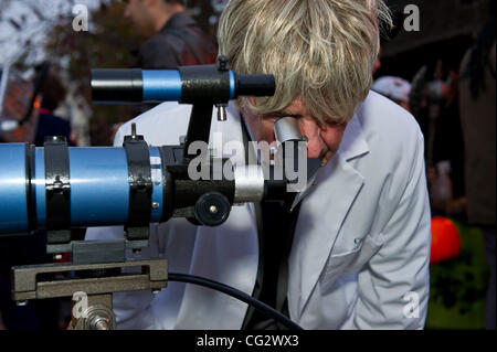 Ottobre 31, 2011 - Ottawa, Ontario, Canada - Governatore Generale David Johnston guarda attraverso un telescopio come parte del suo evento di Halloween a Rideau Hall dove si svolge la parte di lo scienziato pazzo come trucco-o-treaters sono invitati ad esplorare la scienza spaventoso esperimento percorso e visitare i laboratori di H Foto Stock