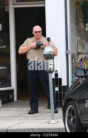 Un vigile mani fuori un parcheggio ticket su Kristen Dunst auto. Los Angeles, California - 23.12.10 Foto Stock