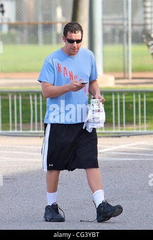 Adam Sandler utilizza il suo telefono cellulare in un gioco di basket in Brentwood. Los Angeles, California - 16.01.11 Foto Stock