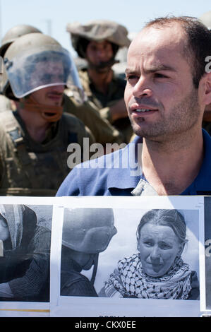 In corrispondenza di una manifestazione settimanale contro l'israele muro di separazione in Cisgiordania città di Al Ma'sara, palestinesi tenere le foto ricordo di Rachel Corrie, che è stato ucciso da un esercito israeliano bulldozer nella Striscia di Gaza in 2003. Il verdetto in una causa civile ha portato dai suoi genitori dovrebbe essere annunciato il 28 agosto. Foto Stock