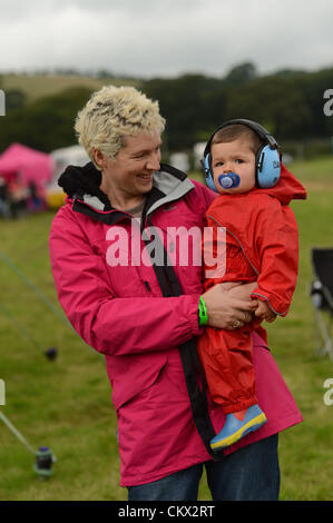 Sabato 25 agosto 2012. Aberystwyth, Wales, Regno Unito. Una madre con il suo bambino, indossare protezioni per le orecchie al grande tributo Festival, il Galles solo musica weekend evento dedicato esclusivamente alle bande tributo. A ferragosto weekend. Foto Stock