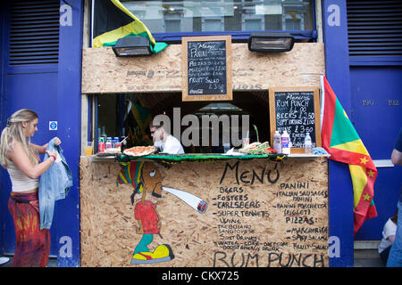 26 ago 2012, Domenica, Nottinghill Carnevale , Nottinghill Gate, London, Regno Unito - 10.05 h - i festaioli raccogliere al di fuori di un rum punch e di stallo.. Credito: Miguel Sobreira / Alamy Live News Foto Stock