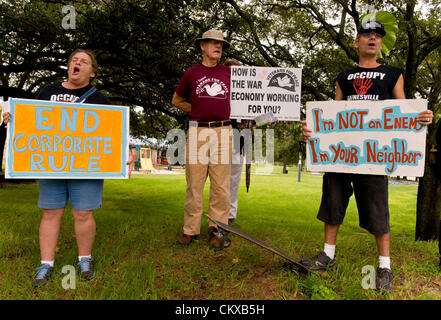 Agosto 27, 2012 - Tampa , FL, Stati Uniti d'America - Persone tenere segni in un parco dove i 5 mila manifestanti erano attese per raccogliere per il 'Marco sulla RNC' la mattina della data pianificata di inizio del 2012 Convention Nazionale Repubblicana. Per la tempesta tropicale avvertenze, il manifestante effettiva affluenza alle urne è stata qualche centinaio. Foto Stock