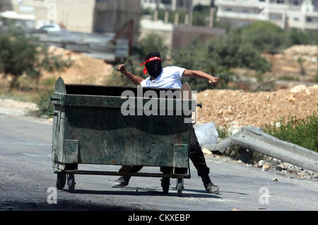 Il 29 agosto 2012 - Ramallah, West Bank, Territorio palestinese - un manifestante palestinese getta pietre contro soldati israeliani al di fuori del Ofer carcere militare, vicino la Cisgiordania città di Ramallah, il 28 agosto 2012, durante una manifestazione di solidarietà con i prigionieri palestinesi detenuti nelle prigioni israeliane (credito Immagine: © Issam Rimawi APA/images/ZUMAPRESS.com) Foto Stock