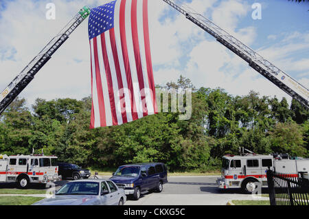 ,Mitchellville, Maryland, Stati Uniti d'America. Il 28 agosto 2012. Le esequie di caduti Prince George County funzionario di polizia Adrian Morris. Camion fuoco forma un arco con una bandiera americana all'ingresso della chiesa Woodstream in Mitchellville, Maryland, dove migliaia di persone è venuto per onorare caduti Prince George County officer Adrian Morris. Morris è stato ucciso quando ha perso il controllo della sua cruiser e si è schiantato inseguono mentre i ladri. Credito: tom carter / Alamy Live News Foto Stock