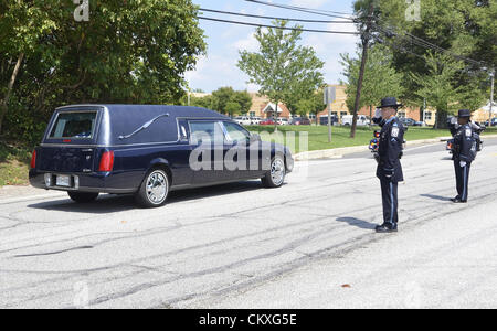 Mitchellville, Maryland, Stati Uniti d'America. Il 28 agosto 2012. Le esequie di caduti Prince George County funzionario di polizia Adrian Morris. Due Anne Arundel County poliziotti salutare il funebre contenente il corpo di caduto Prince George County Officer Adrian Morris come si fa il suo modo per il Cimitero di Lakemont in Davidsonville, Maryland. Morris è stato ucciso quando ha perso il controllo della sua cruiser e si è schiantato mentre perseguono i ladri. Credito: tom carter / Alamy Live News Foto Stock