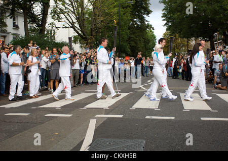 Londra, Regno Unito. Il 29 agosto 2012. Cinque dei torchbearers tra le 580 persone appositamente scelti per portare la fiamma paralimpica l'ultimo giorno del suo viaggio verso lo Stadio Olimpico, mercoledì 29 agosto 2012, sono allietate attraverso le strisce pedonali al di fuori della registrazione di Abbey Road Studios di San Giovanni Bosco ha reso famoso dai Beatles. Credito: Richard Slater / Alamy Live News Foto Stock