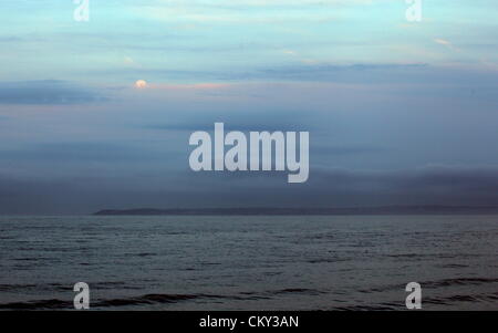 1 settembre 2012. Swansea, Regno Unito. Luna piena di scomparire dietro le nuvole sulla Baia di Swansea come visto da Port Talbot nelle prime ore del mattino. Il "Blue Moon" come viene chiamato è quando due lune piene si verificano nel mese di agosto, andando in settembre. La luna è il più vicino alla terra e sembra molto più grande e più luminoso. Foto Stock