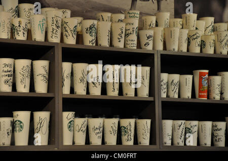 Londra, UK, mercoledì 5 settembre 2012. Starbucks Coffee cups, firmato dai Giochi Olimpici e Paralimpici di concorrenti, allineate su un ella Foto Stock