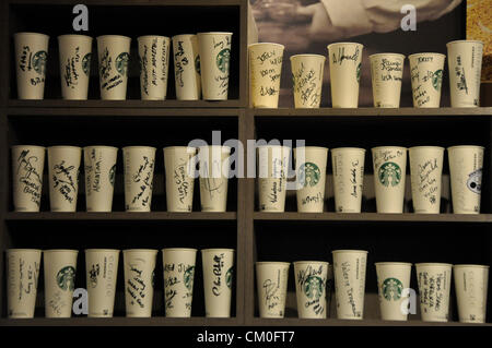 Londra, UK, mercoledì 5 settembre 2012. Starbucks Coffee cups, firmato dai Giochi Olimpici e Paralimpici di concorrenti, allineate su un ella Foto Stock