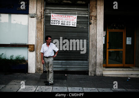 Salonicco, Grecia. 8 Settembre, 2012. Uomo in piedi nella parte anteriore del negozio chiuso che legge 'affitto'. Il rally tenutasi a Salonicco primario di sindacati, partiti politici e rappresentanti delle istituzioni, nell'apertura del 77th TIF. Nel complesso si stima di avere partecipato nelle marche almeno 30.000 persone. Foto Stock