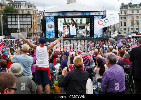 10 Settembre, 2012. Spettatori guarda Olimpici e Paralimpici parade trasmesso in diretta su un grande schermo, Trafalgar Square, London REGNO UNITO Foto Stock