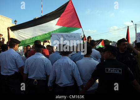 Sett. 12, 2012 - Ramallah, West Bank, Territorio palestinese - ufficiali della polizia palestinese stand barriera nella parte anteriore di dimostranti durante una manifestazione di protesta contro il Protocollo di Parigi e l'accordo di Oslo, chiave di entrambi gli accordi che regolano i legami economici tra i palestinesi e gli israeliani in Cisgiordania città di Ramallah l 11 settembre 2012. Palestinesi in Cisgiordania sono state dimostrando negli ultimi dieci giorni oltre il costo della vita e in particolare il prezzo del carburante, che è passato da sei a otto sicli (da $ 1,50 a $ 2,00, 1,18 a 1,57 euro) per litro negli ultimi due mesi da solo (cred Foto Stock