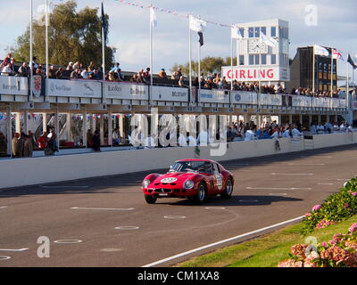 Goodwood pratica giorno Venerdì, Settembre 14th.2012. Numero 22 Ferrari che porta una brillante livrea rosso si avvicina al traguardo davanti a ingegneri e spettatori ai box. Foto Stock