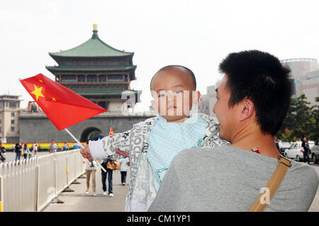 Xian, Cina. Sabato 15 Settembre, 2012. Un giovane padre con il suo piccolo figlio di tenere una bandiera nazionale cinese passeggiate per il centro della città per unire i manifestanti , che protestavano a la sovranità delle isole di pesca(Isole Diaoyu). Foto Stock